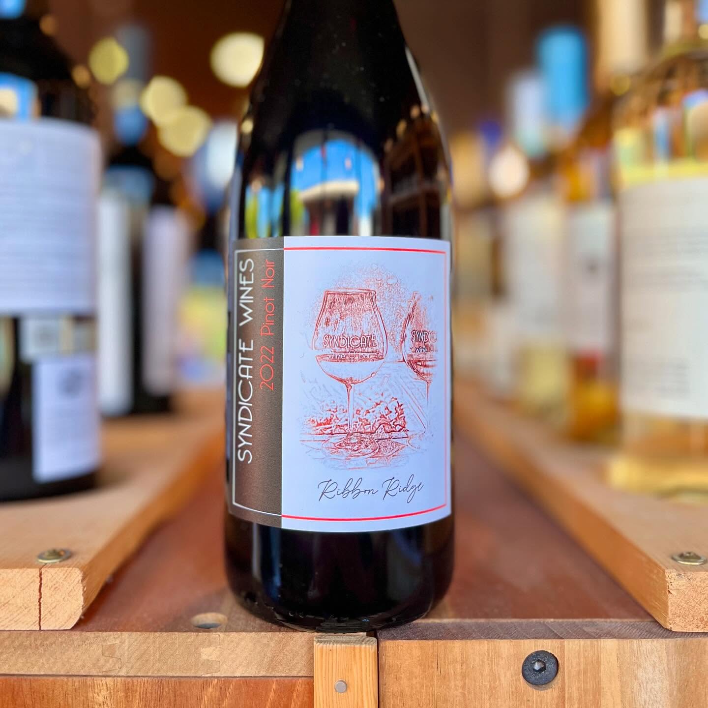 a bottle of wine on a wooden shelf